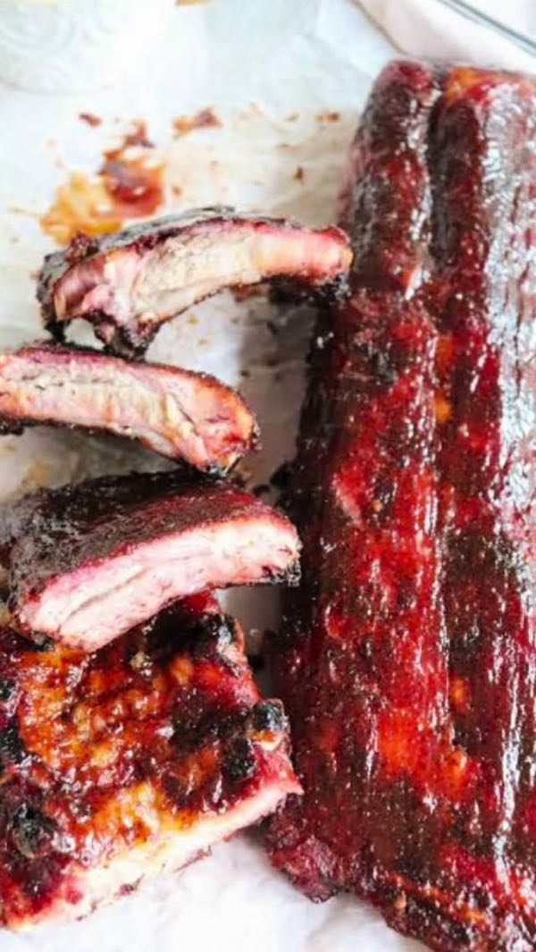 Sliced smoked baby back ribs with a pink smoke ring
